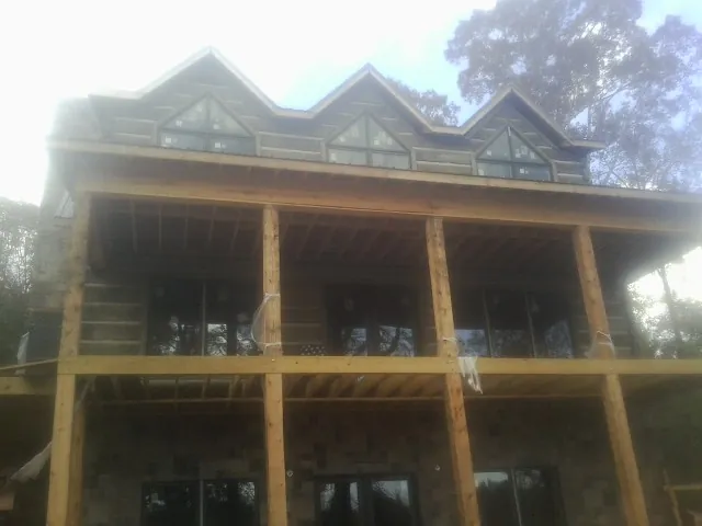 Dormers and porch framing on a large log home under construction — Roof Coating work by our crew in Glendora